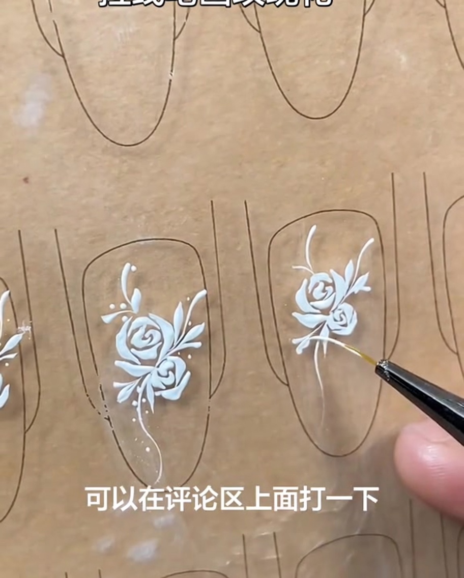 Diseño de nail art terminado con una rosa blanca, enredadera, hojas y pequeños puntos decorativos, claramente visibles en el tip de uña.