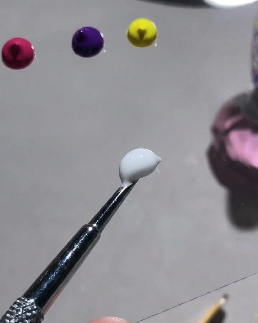 Una paleta que muestra varios polvos de colores vibrantes y una herramienta para mezclarlos con gel yeso blanco.