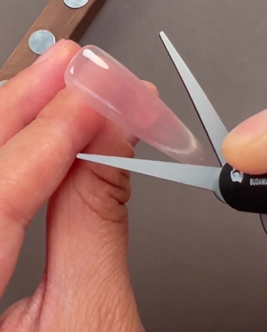 Primer plano de uñas con un acabado de gel cat-eye de cristal translúcido.