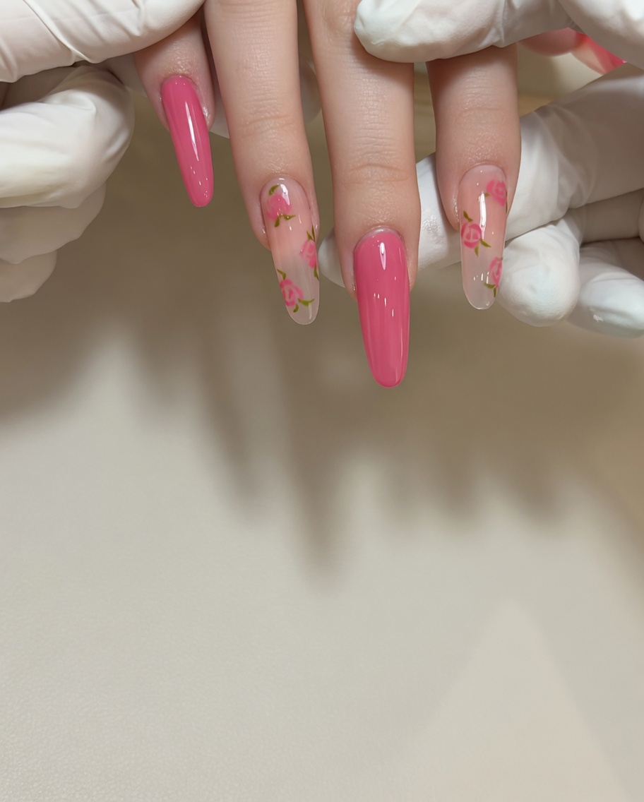 Primer plano de un pincel de detalle fino aplicando esmalte de gel rojo para crear un pétalo de rosa en una uña de tono natural.