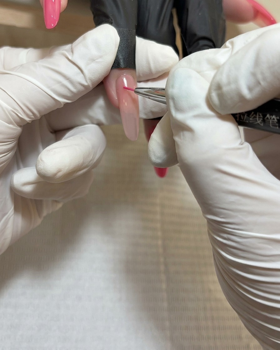 Primer plano de un pincel de línea aplicando gel rojo profundo en el centro del tercer grupo de pétalos.