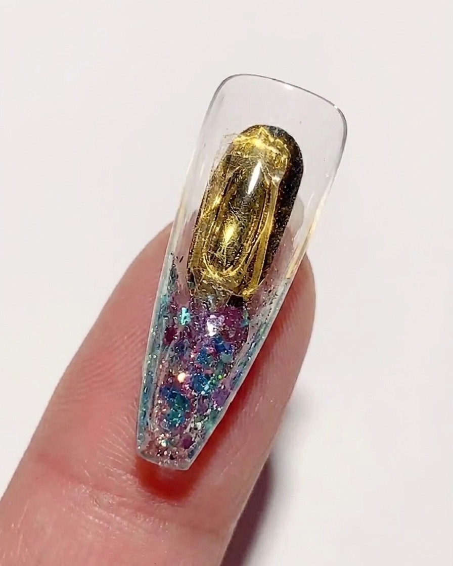 Aplicando un pegamento duro y espeso para uñas sobre la superficie interior de color dorado de un tip.