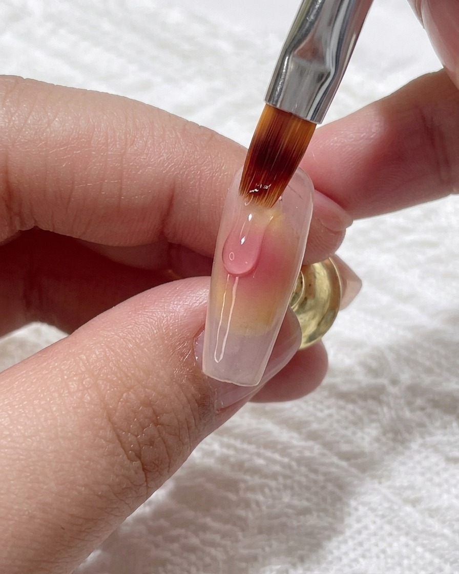 Aplicando una gota fresca de gel rosa sobre el degradado existente para intensificar el color.