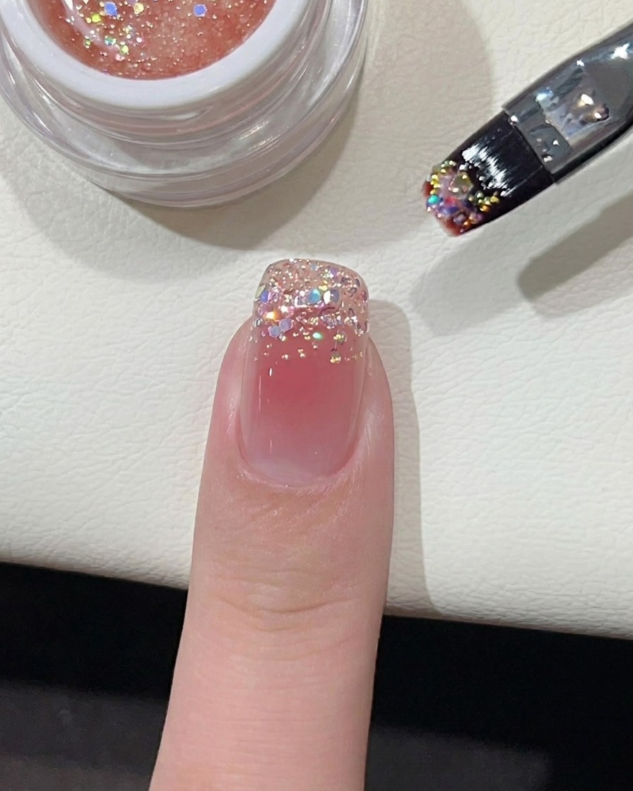 Un pequeño punto de esmalte de gel rosa vibrante colocado en el centro de una uña con base nude.