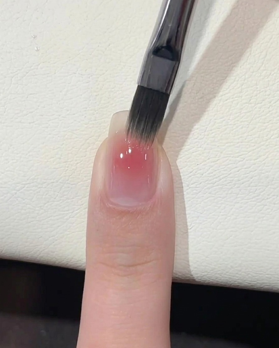 Una mano colocada dentro de una lámpara profesional de uñas UV para el curado.