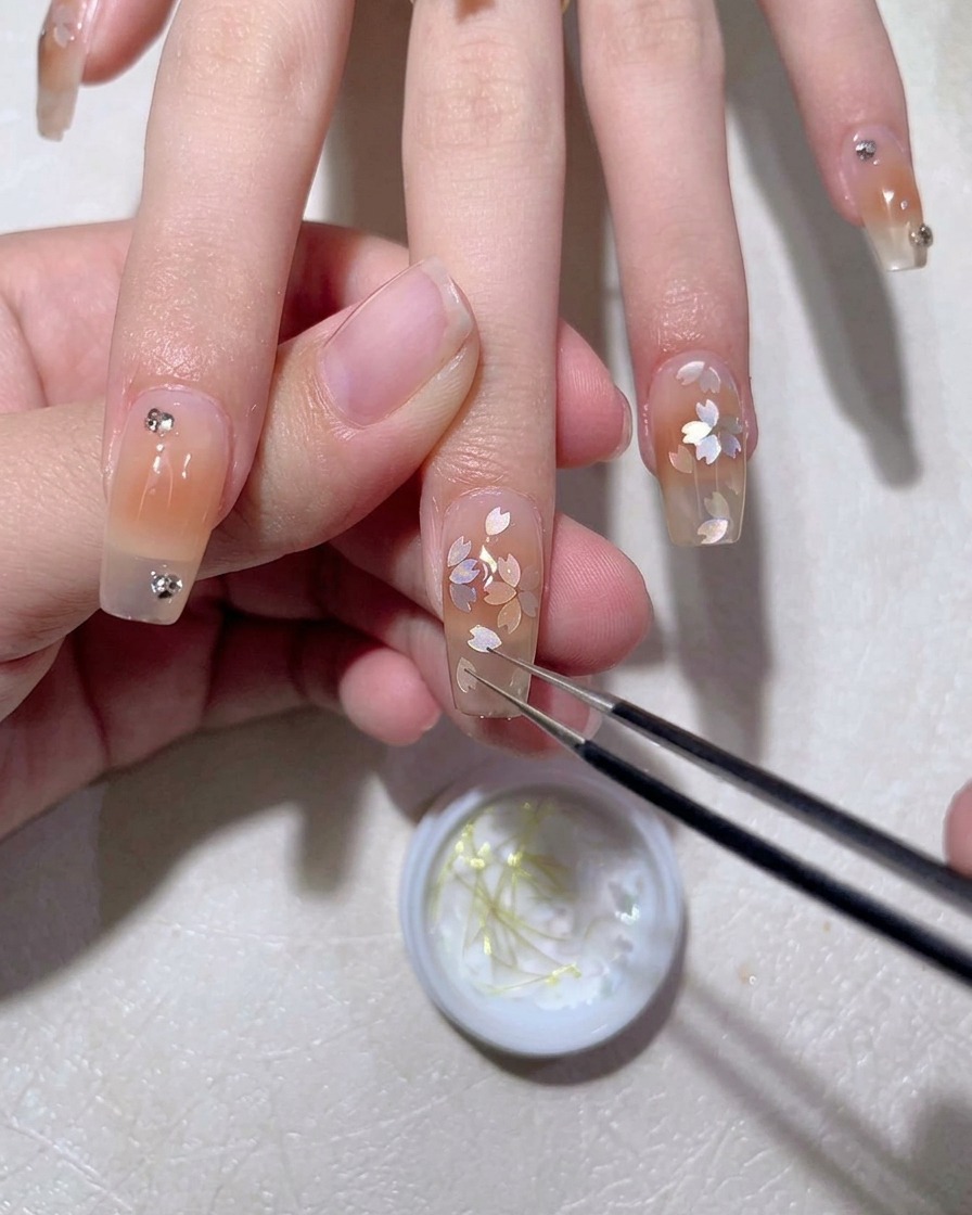 Un pincel de gel aplicando una capa lisa de top coat sobre un diseño de uñas terminado.