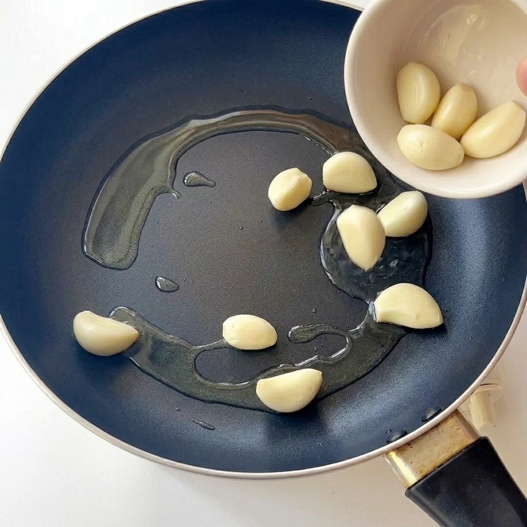 Un pincel siendo utilizado para difuminar purpurina plateada hacia arriba en una uña para crear un efecto ombré.