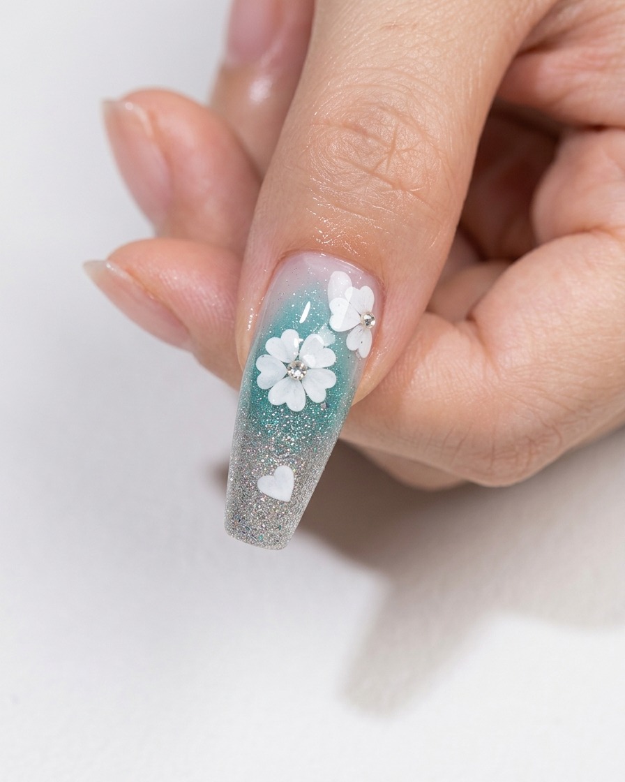 Un pincel de arte de uñas aplicando una capa de top coat transparente brillante sobre un diseño de uñas floral con cristales incrustados.