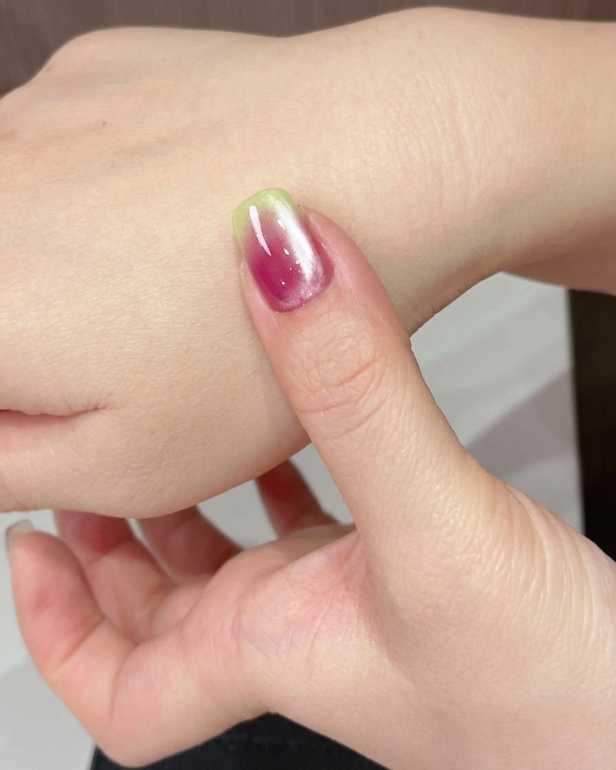 Una mano bajo una lámpara UV curando el gel ojo de gato recién aplicado.