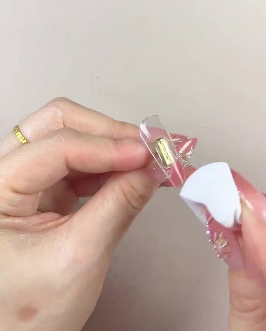 Una esponja de maquillaje moviéndose de izquierda a derecha sobre la uña para difuminar el color del gel.