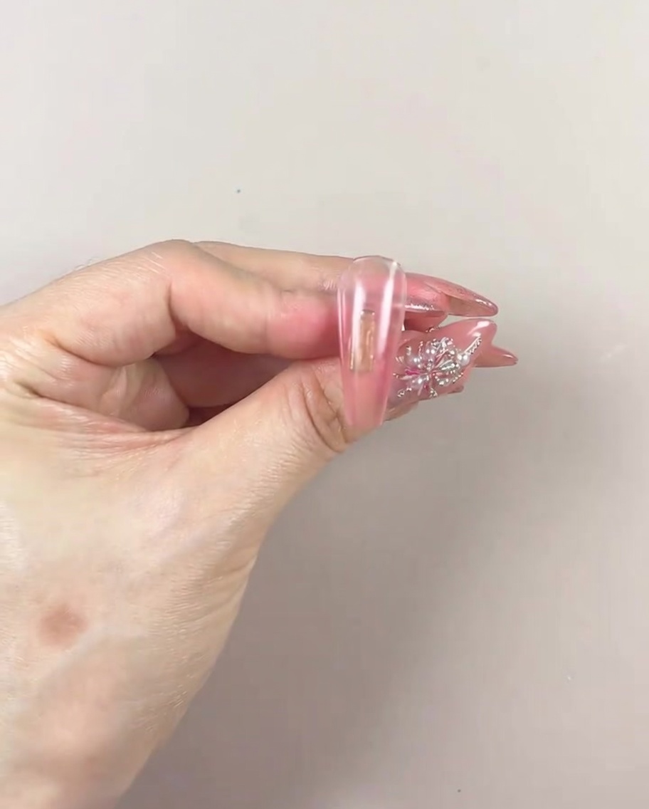 Una mano arreglada colocada dentro de una lámpara de uñas UV/LED para curar la capa de degradado de gel.
