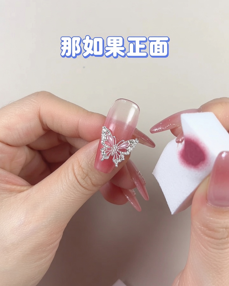 Una sección limpia de una esponja cosmética siendo utilizada para suavizar una zona concentrada de esmalte en gel en una uña.