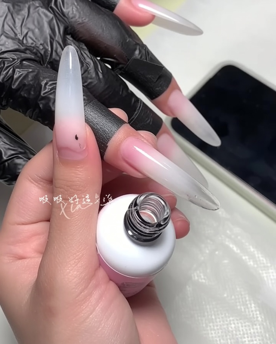 Un pincel siendo utilizado para refinar el borde del esmalte cerca de la cutícula.