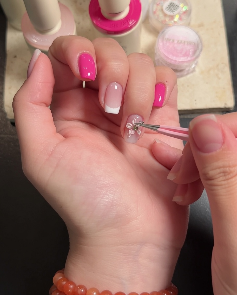 Un pincel aplicando top coat transparente alrededor de los bordes de una flor 3D.
