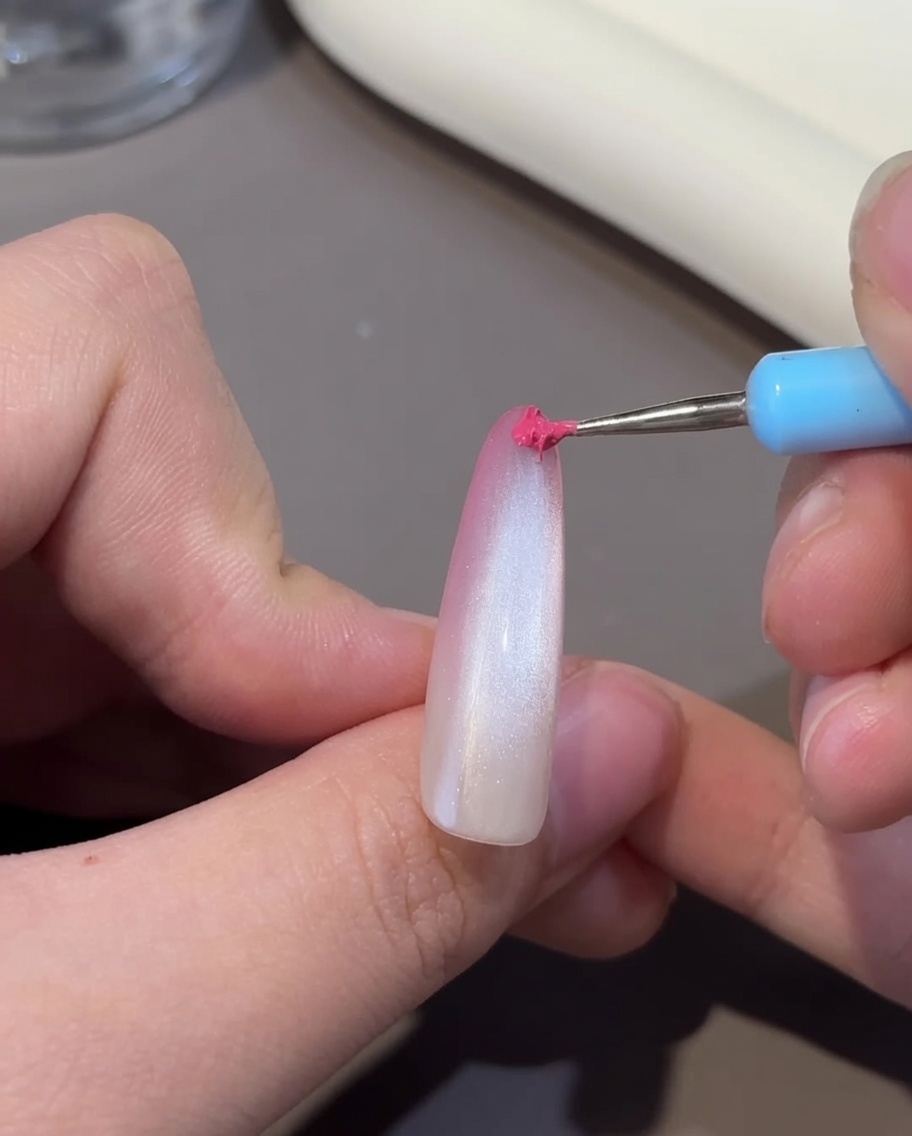 Una uña con el efecto cat-eye siendo curado dentro de una lámpara UV/LED.