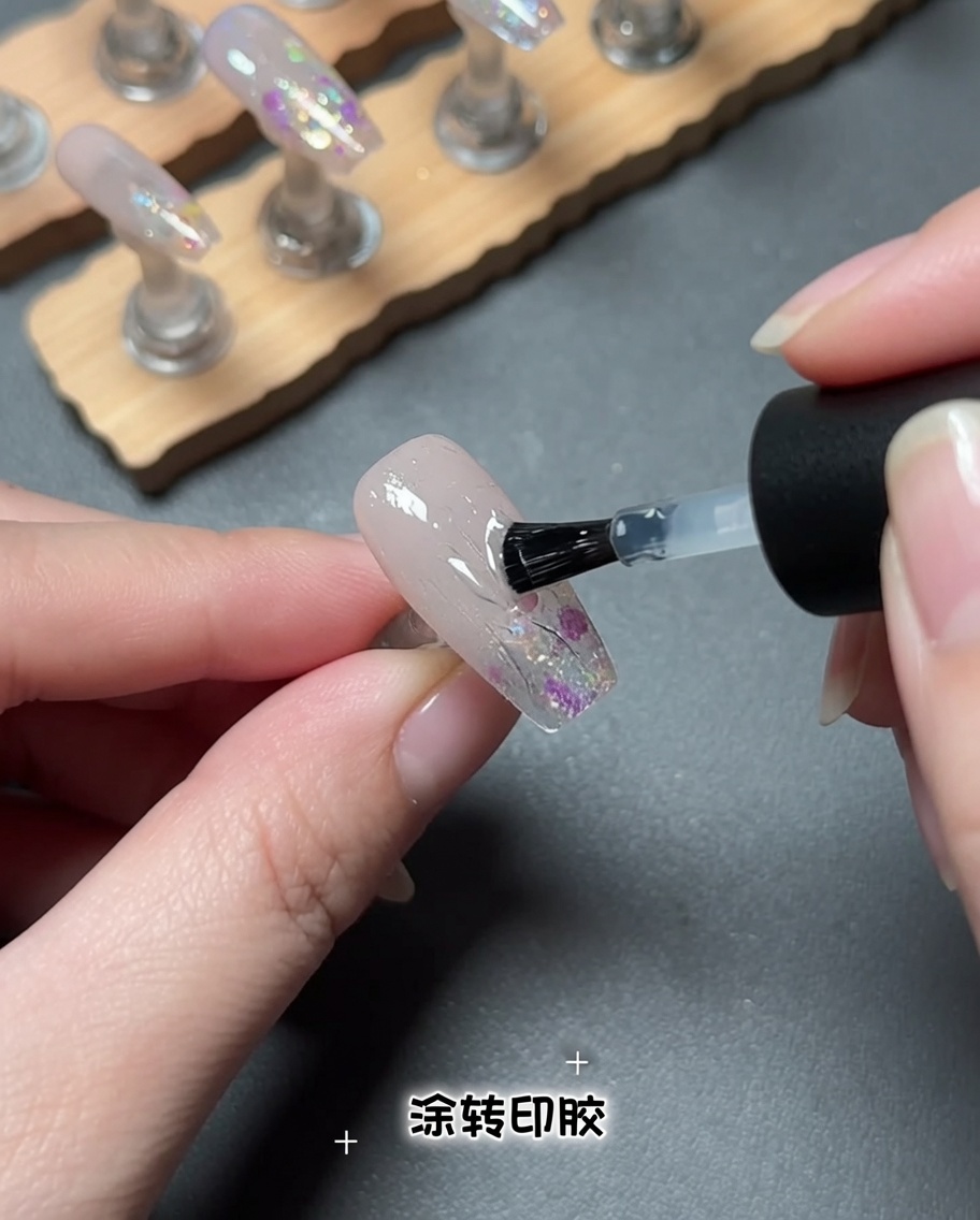 Un pincel aplicando un producto de gel transparente sobre una superficie de uña.