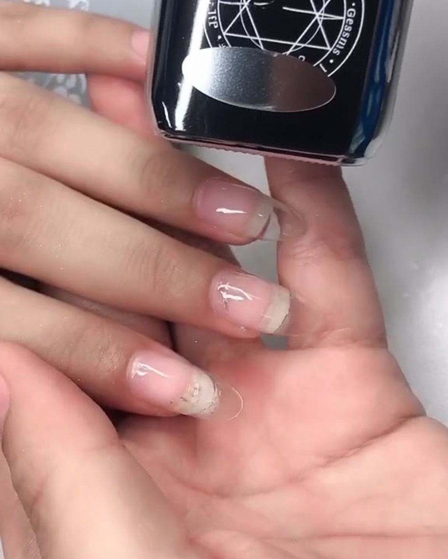 Primer plano mostrando el top coat de gel efecto espejo siendo aplicado sobre la uña.