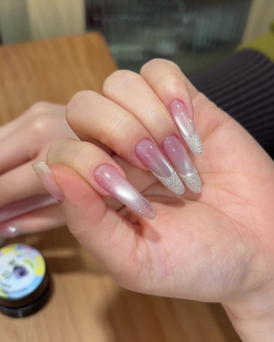 Uñas posicionadas dentro de una lámpara UV portátil para el proceso de curado.