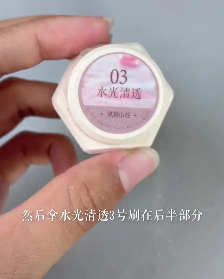 Aplicación de un gel rosa translúcido y brillante sobre la zona de la base del tip.