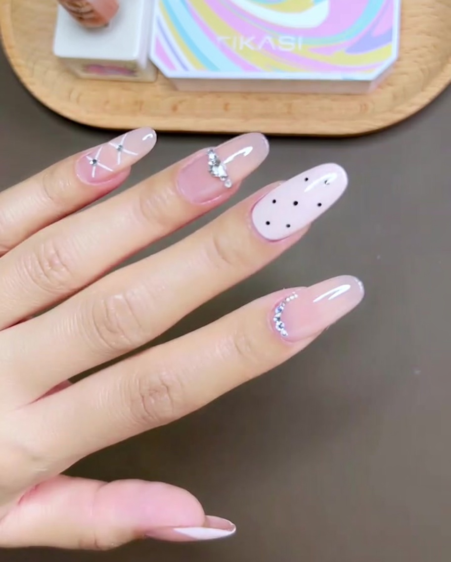 Primer plano de un pincel de esmalte de gel rosa aplicando color en la uña del dedo medio.