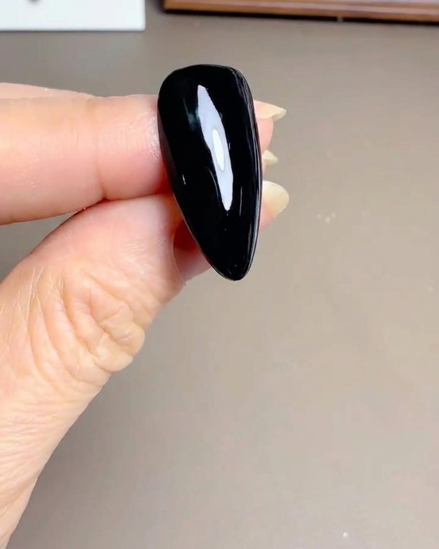 Primer plano de una esponja pequeña aplicando esmalte amarillo en el centro de la margarita blanca.