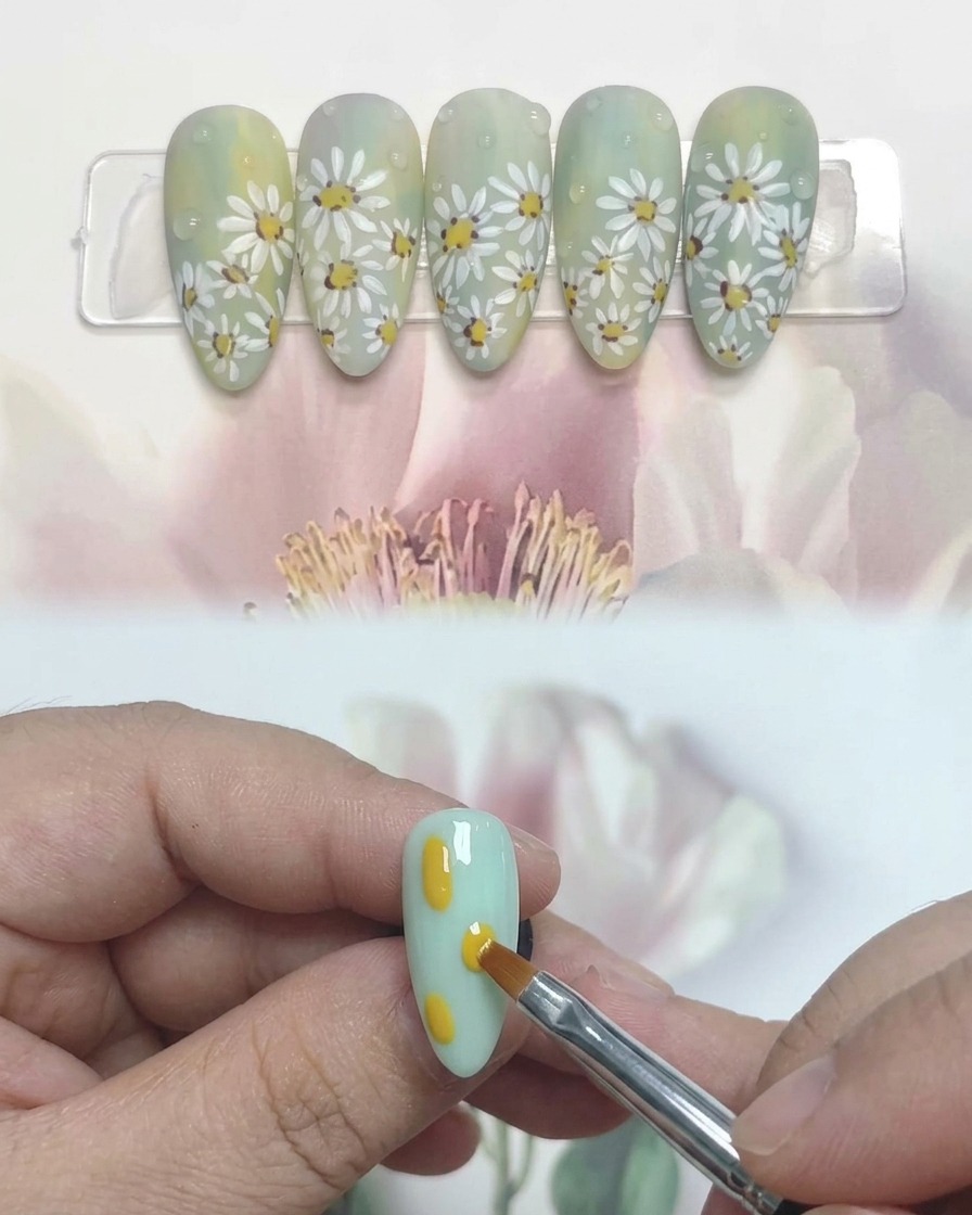 Vista en primer plano de una mano con uñas decoradas con margaritas descansando dentro de una lámpara de uñas UV profesional.