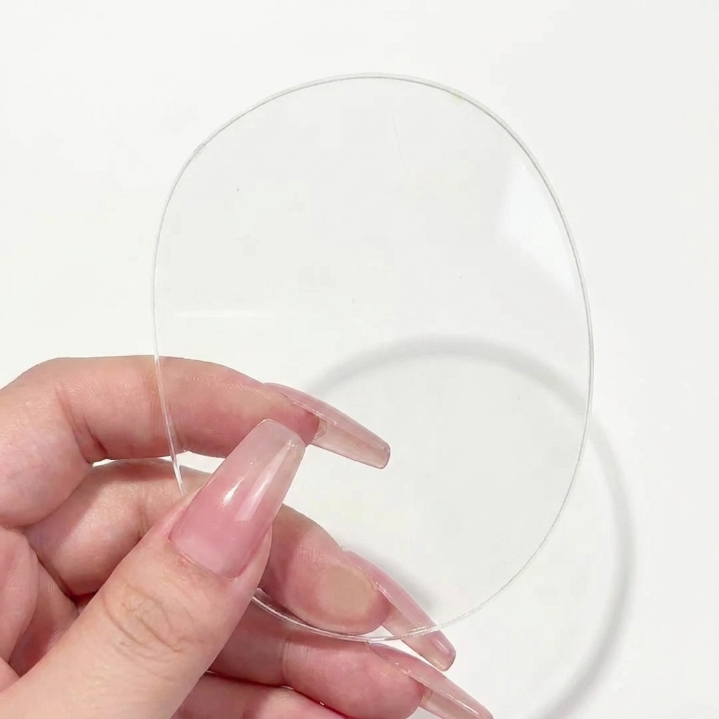 Un primer plano de un pincel delineador dibujando una línea horizontal para formar una cruz sobre una paleta transparente.