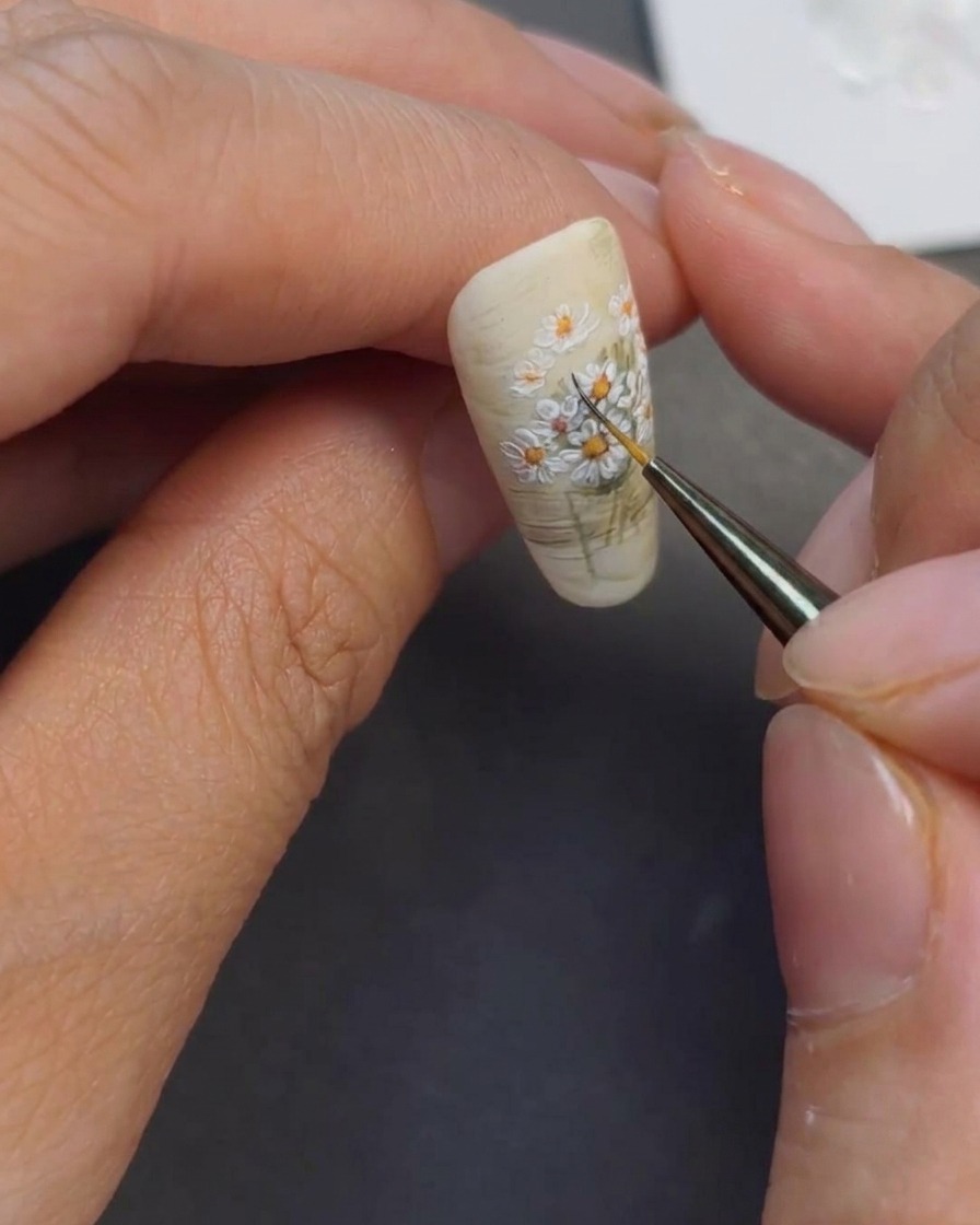 Un pincel de detalle añadiendo líneas verde oscuro a los tallos pintados.