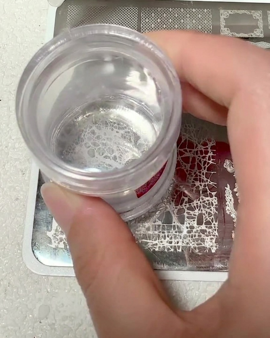 Un cabezal de estampador de silicona transparente mostrando el patrón de encaje blanco recogido.