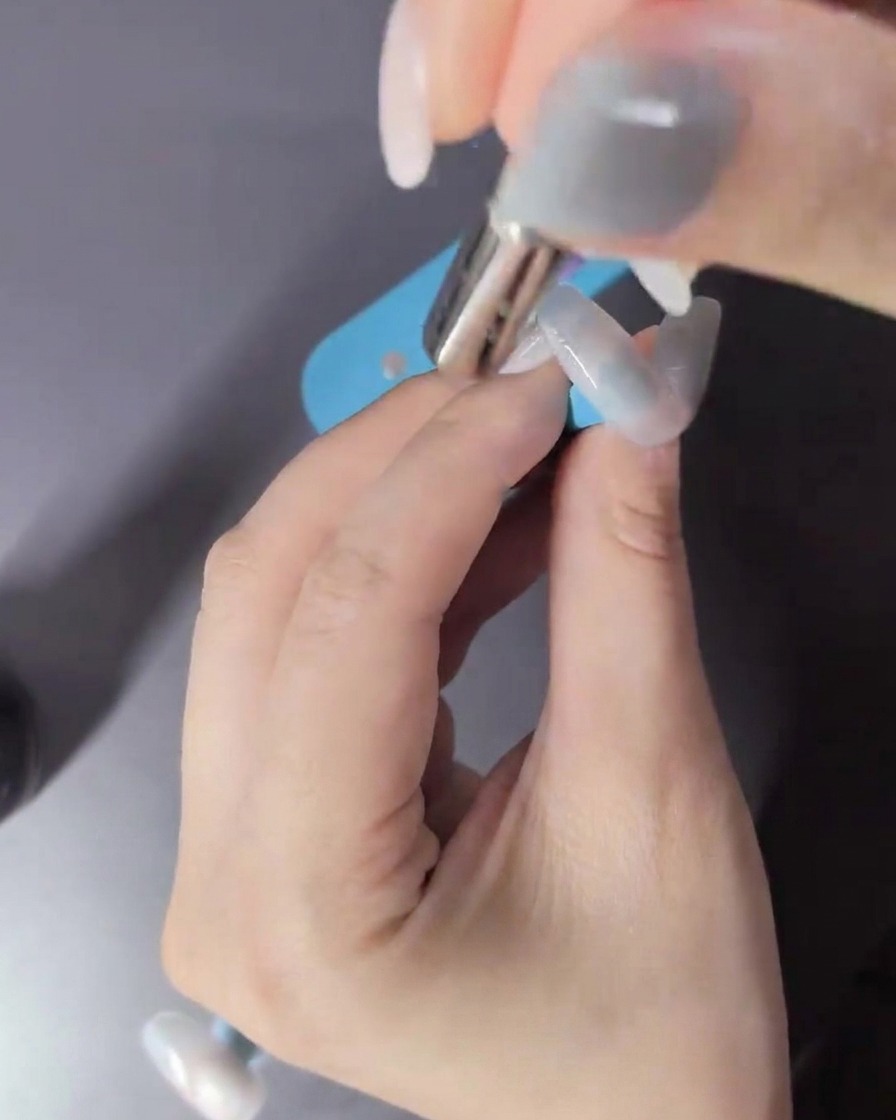 Una mano dentro de una lámpara LED curando el esmalte de gel.