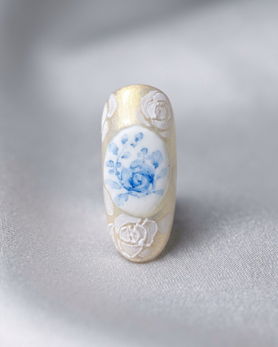 Un diseño de uña terminado que presenta una rosa azul central rodeada de rosas blancas 3D y trabajo de encaje intrincado.