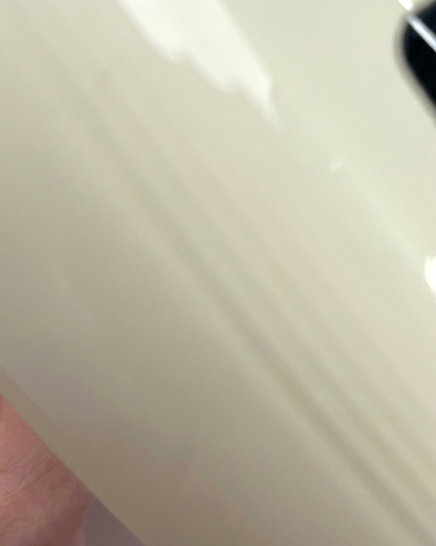 Vista de un tip de uña transparente siendo curado bajo la luz púrpura de una lámpara UV/LED.