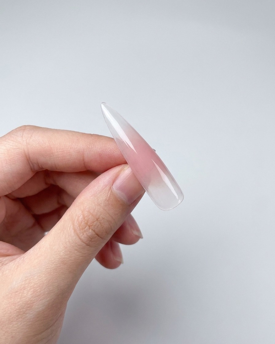 Primer plano de una punta de uña con gel magnético mostrando un efecto brillante creado con un imán.
