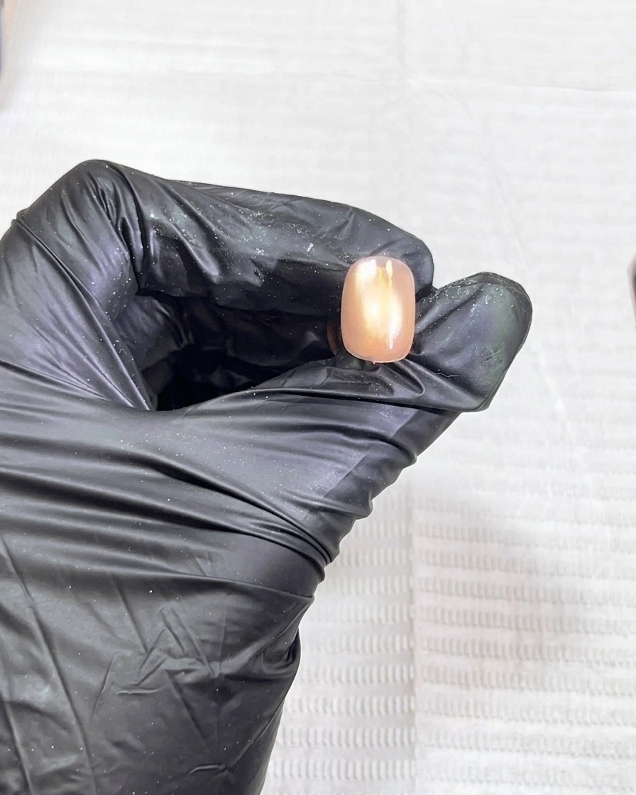 La uña siendo colocada dentro de una lámpara UV para el proceso de curado.