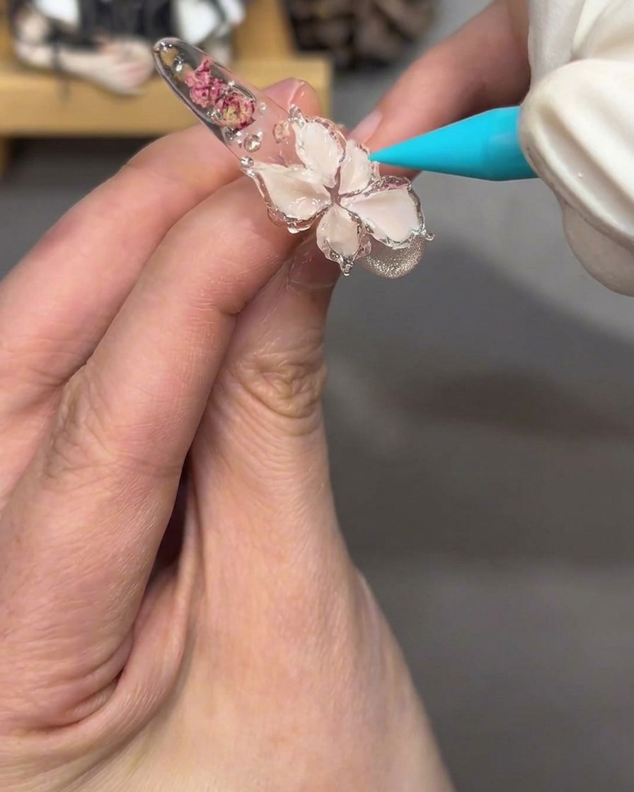 Vista en primer plano del diseño floral en la uña, luciendo brillante y traslúcido tras aplicar gel jelly transparente.