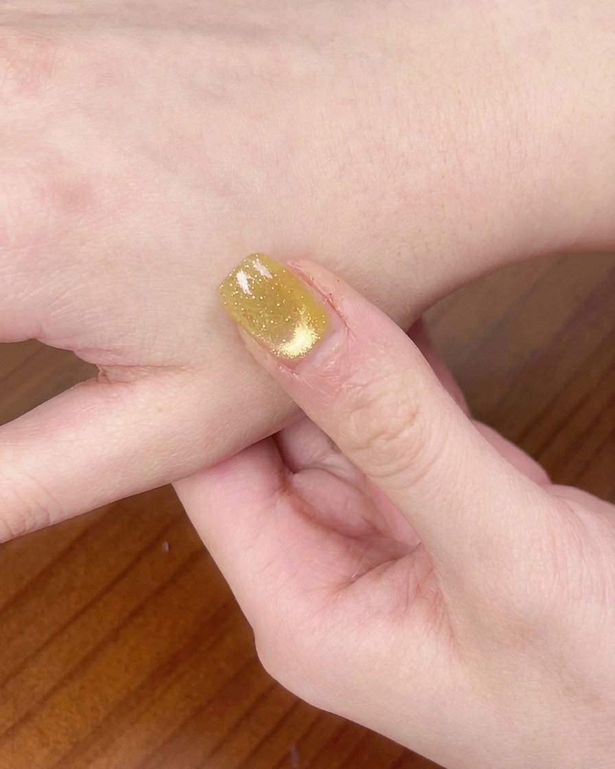 Una mano descansando dentro de una lámpara de uñas UV/LED curando el esmalte en gel.