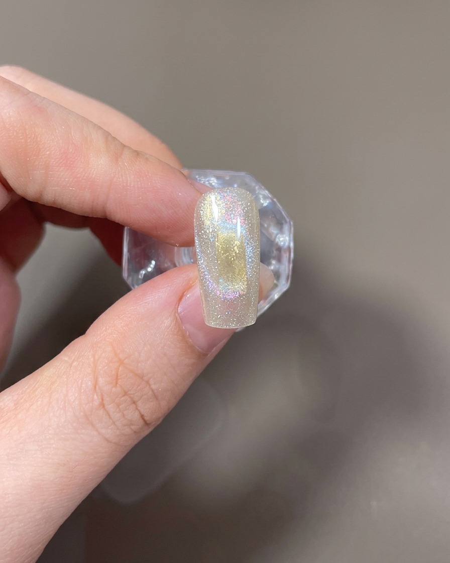 Un imán rectangular sostenido horizontalmente junto a la uña para formar una luz de ojo de gato ancha.