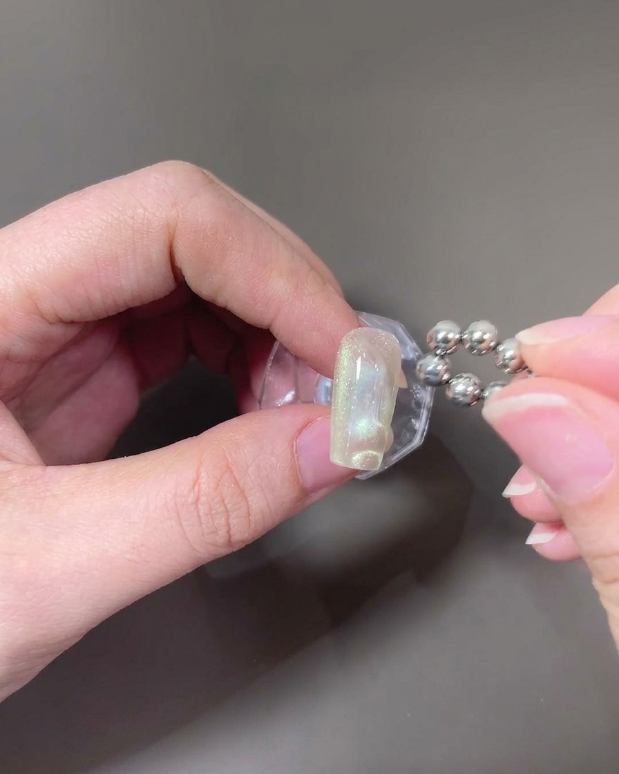Un imán de punta esférica siendo utilizado para crear patrones de ondas en el gel ojo de gato húmedo.