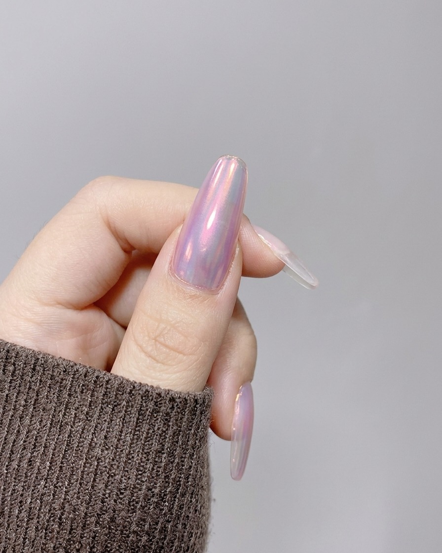 Una mano posicionada bajo una lámpara UV/LED de mano compacta y rosa para curar la extensión de uña.
