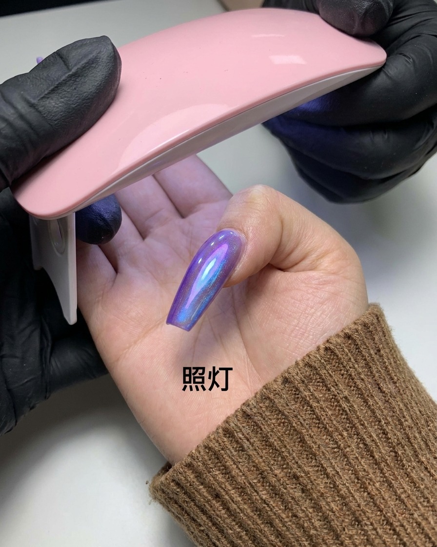 Un dedo con el patrón magnético cat-eye completado siendo sostenido bajo una pequeña lámpara de uñas UV/LED rosa.