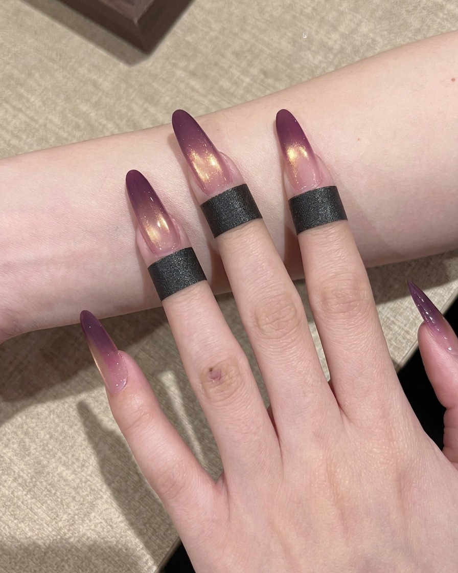 Una mano con uñas pintadas con efecto ombré posicionada dentro de una lámpara UV profesional para curar el esmalte.