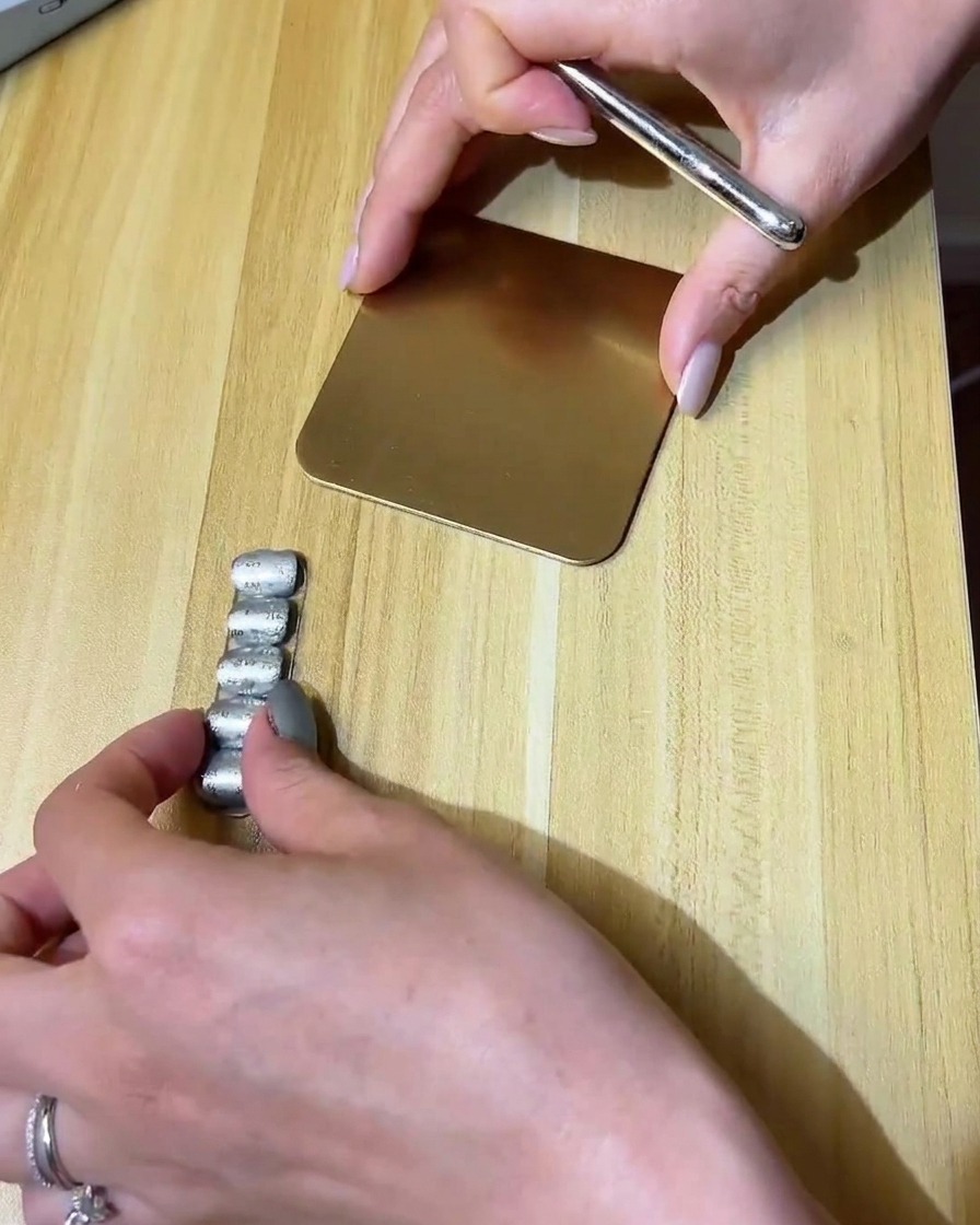 Un pincel fino de detalle pintando un diseño de nube pequeña con gel transparente sobre una uña mate.
