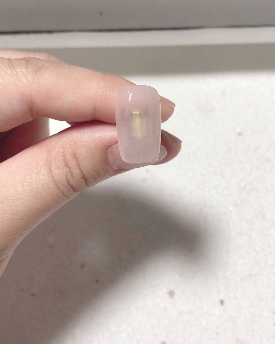 Una uña recién pintada colocada dentro de una lámpara profesional para uñas para su curado.
