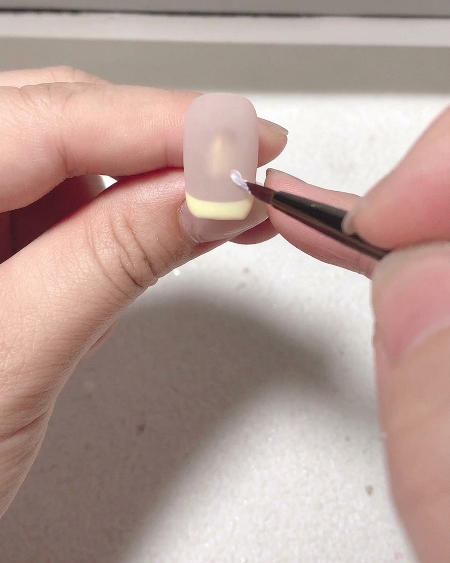 La uña con el top coat mate secándose dentro de la lámpara UV/LED.