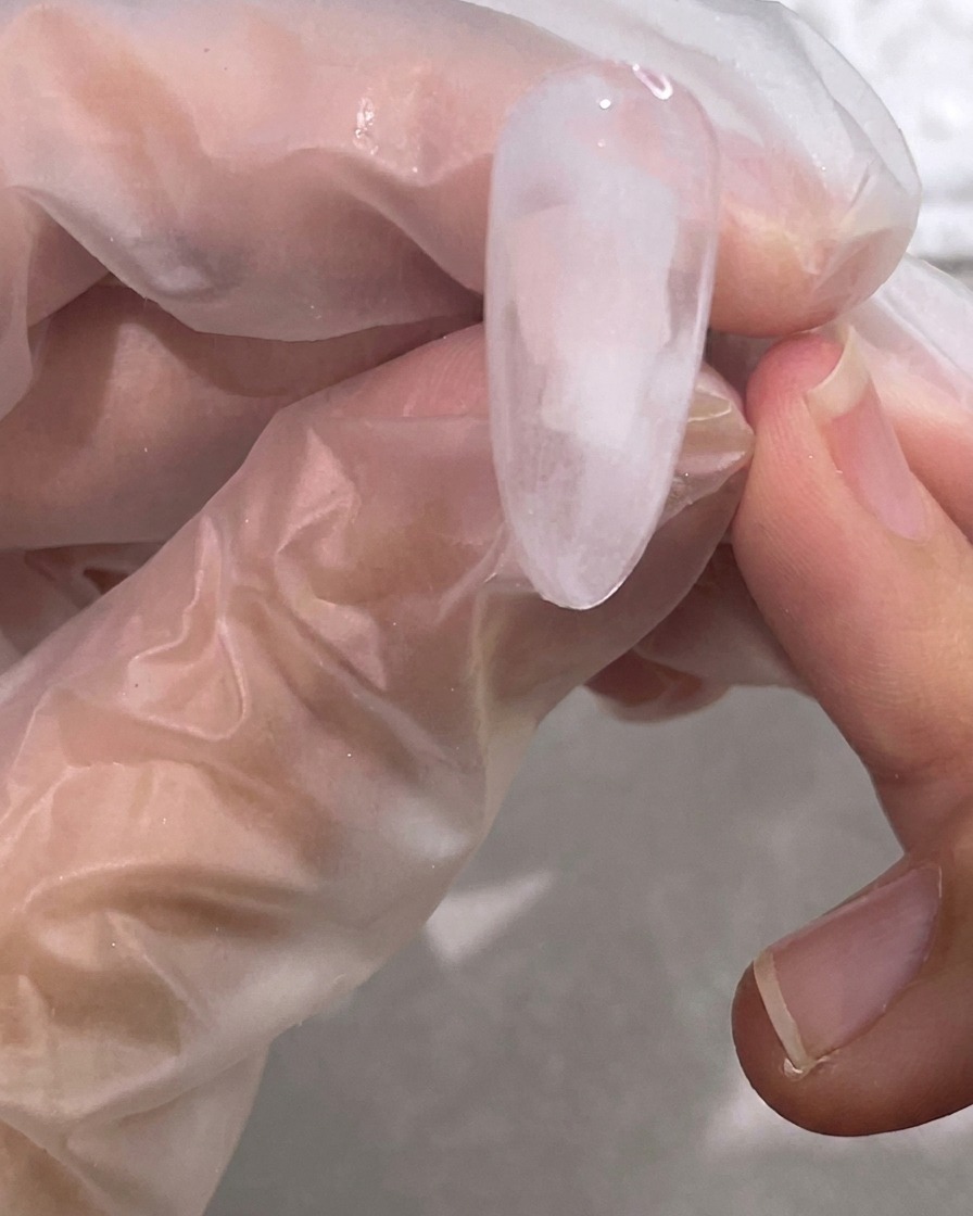 Un pincel mezclando el gel blanco con la base transparente para crear un efecto nublado.