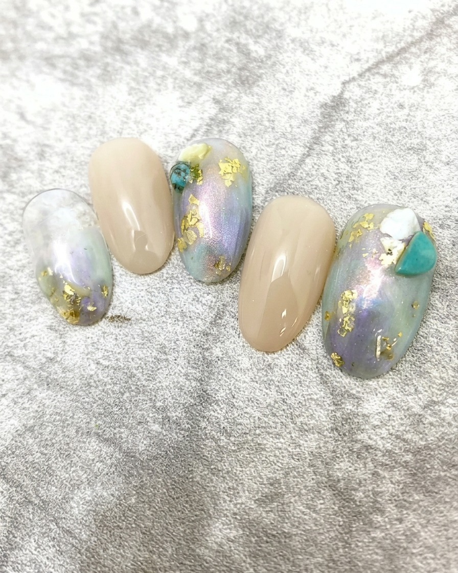 Una vista de primer plano de una mano con el arte de uñas de mármol y lámina de oro completado curándose dentro de una lámpara de uñas UV/LED profesional.