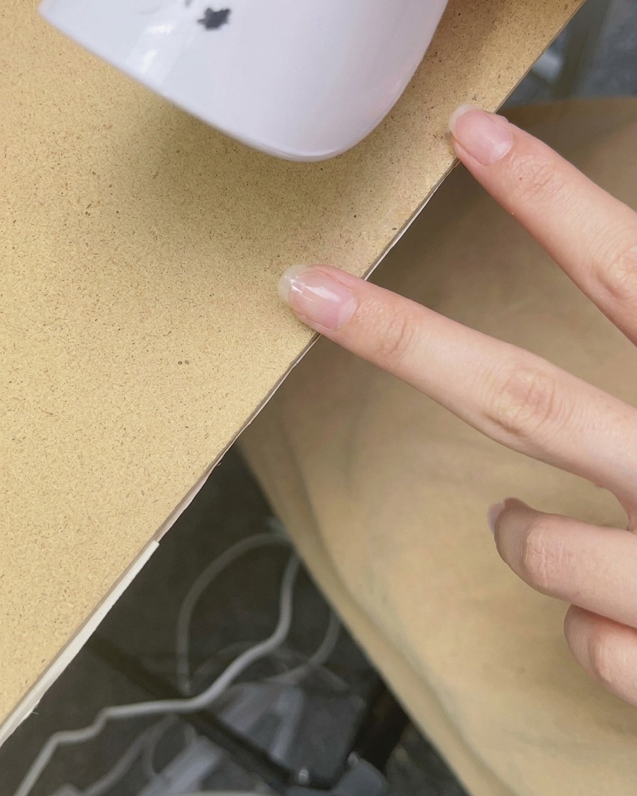 Una mini lámpara UV/LED de mano sobre una uña para curar el esmalte.