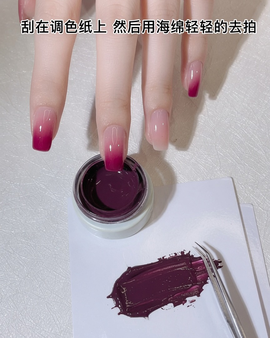 Una esponja de maquillaje blanca siendo presionada sobre una fina capa de gel púrpura-rosa en una paleta.