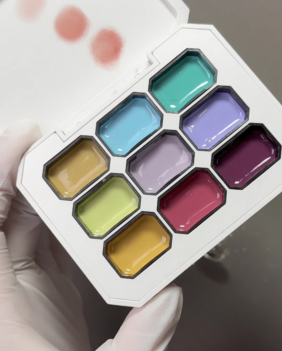 Una paleta con varios colores de gel pastel y una esponja de maquillaje utilizada para recoger los pigmentos.