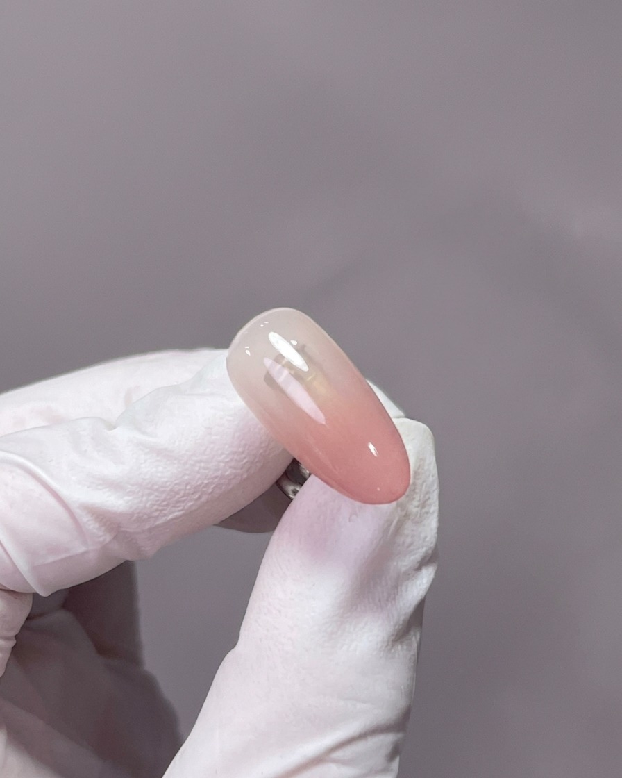 Primer plano de una mano descansando dentro de una lámpara de uñas profesional UV/LED, con las uñas centradas bajo la luz.